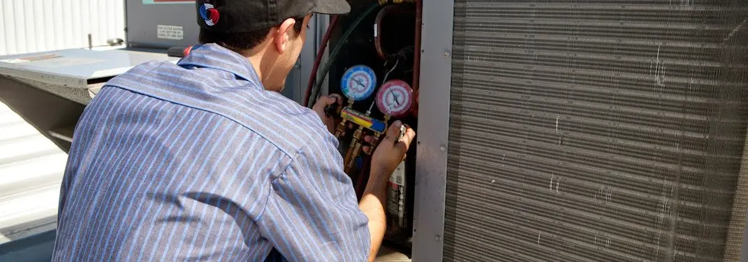HVAC technician servicing a condenser unit in Todd Creek