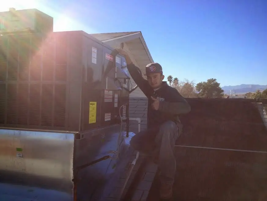 HVAC technician performing Heat Pump Repair on a rooftop unit in Todd Creek